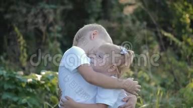 金发哥哥抱着妹妹.. 孩子们在农村户外玩耍。 儿童暑期娱乐活动.. 健康
